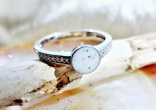 Sterling silver ring, with diamantés on the shoulders of the ring either side of the bezel containing the breast milk.